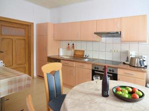 a kitchen with a table with a bowl of fruit on it at Lovely Farmhouse in Friedrichsfeld with Garden in Trendelburg