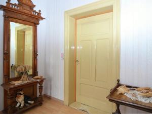 una habitación con una puerta y un perro sentado junto a un espejo en Lovely Farmhouse in Friedrichsfeld with Garden, en Trendelburg
