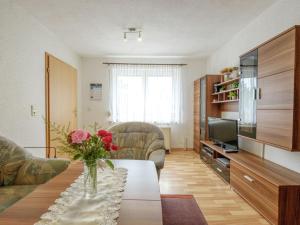 ein Wohnzimmer mit einer Blumenvase auf dem Tisch in der Unterkunft Holiday home in Hasselfelde with private terrace in Stiege