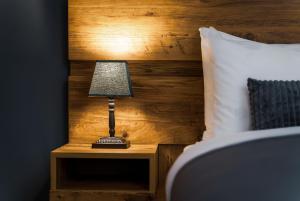 a lamp on a night stand next to a bed at Reed Hotel Tbilisi in Tbilisi City
