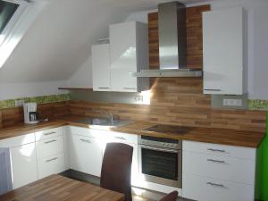 a kitchen with white cabinets and a sink at Cosy Apartment in Wilsecker near the Forest in Kyllburg