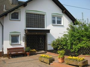 a house with a bench and flowers in front of it at Cosy Apartment in Wilsecker near the Forest in Kyllburg