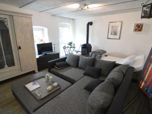 ein Wohnzimmer mit einem grauen Sofa und einem Tisch in der Unterkunft Romantic ground floor apartment for 2 people in Immerath