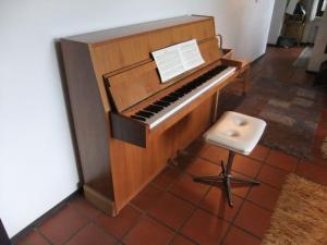 a wooden piano and a stool in a room at Holiday home in Lissendorfer with terrace in Lissendorf