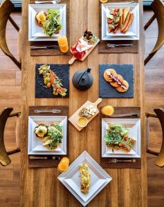 una mesa de madera con platos de comida. en Reed Hotel Tbilisi en Tiflis