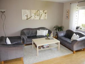 a living room with two leather couches and a coffee table at Apartment in Niederehe near the forest in Üxheim