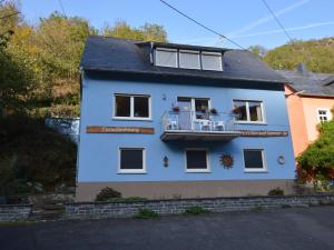 ein blaues Haus mit einem Balkon an der Seite in der Unterkunft Holiday home in nice surrounding in Veldenz