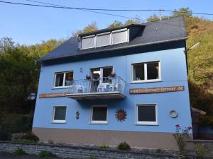 ein blaues Haus mit Balkon auf einem Hügel in der Unterkunft Holiday home in nice surrounding in Veldenz