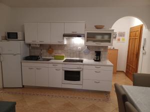 eine Küche mit weißen Schränken, einer Spüle und einem Kühlschrank in der Unterkunft LEDA in Medulin
