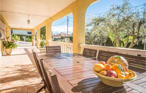 - un bol de fruits sur une table en bois sur une terrasse dans l'établissement Cozy Home In Urbanizacin La Sima With Outdoor Swimming Pool, à Torre de Baba