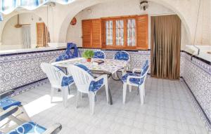 サンタ・ポラにあるAwesome Home In Santa Pola With 3 Bedrooms And Wifiのダイニングルーム(テーブル、青と白の椅子付)