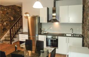 a kitchen with white cabinets and a glass table at 3 Bedroom Lovely Home In Paralio Astros in Koútroufa
