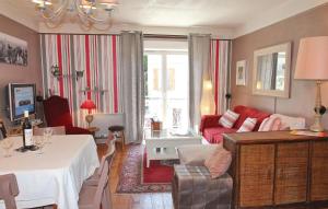 サン・ボネ・アン・シャンソールにあるBeautiful Apartment In St Bonnet En Champsaur With 2 Bedrooms And Wifiのリビングルーム(赤いソファ、テーブル付)