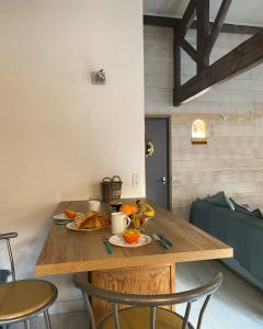 een houten tafel met twee borden eten erop bij Maison Vert d'Eau in Grand-Village-Plage