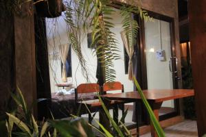 une salle à manger avec une table et des plantes dans l'établissement เฮือนกว่าง, à Pua