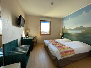 um quarto de hotel com duas camas e uma televisão em La Tour D'ivoire em Reignier