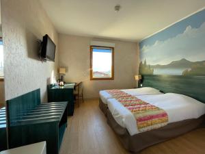 a hotel room with two beds and a television at La Tour D'ivoire in Reignier