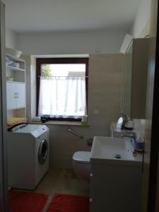 a bathroom with a toilet and a sink and a window at Ruhe und Bequemlichkeit in Frauendorf