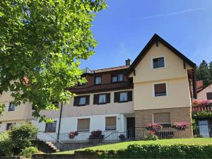 ein großes weißes Gebäude mit einem Dach in der Unterkunft Panoramic view Apartment in Baiersbronn with Garden in Baiersbronn