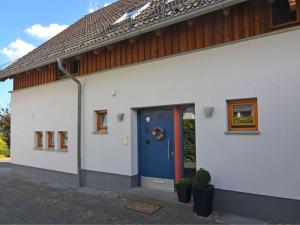 uma casa branca com uma porta azul e janelas em Apartment in Eslohe with terrace em Eslohe