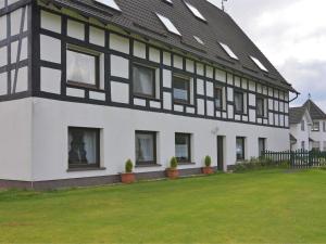 a black and white building with a yard at Apartment with panoramic views in Attendorn