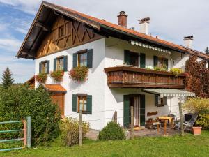 Casa con balcón de madera y mesa en Apartment near the Halblech ski resort, en Trauchgau