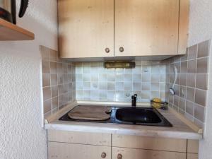 una cocina con fregadero y armarios de madera en Apartment near the Halblech ski resort, en Trauchgau