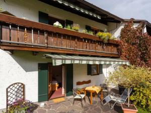 eine Terrasse mit einem Tisch und Stühlen sowie einem Balkon in der Unterkunft Apartment near the Halblech ski resort in Trauchgau