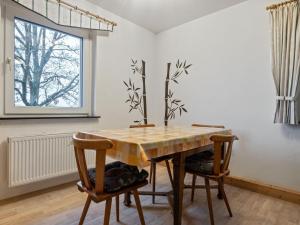 メーデバッハにあるQuaint holiday home in Sauerland in natureのダイニングルーム(木製テーブル、椅子付)