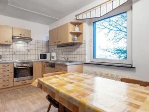 メーデバッハにあるQuaint holiday home in Sauerland in natureのキッチン(テーブル付)、大きな窓が備わります。