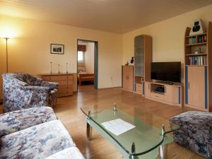 uma sala de estar com uma mesa de vidro e uma televisão em Enchanting Holiday Home in B defeld with Terrace em Schmallenberg