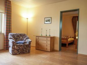 uma sala de estar com uma cadeira e uma cómoda em Enchanting Holiday Home in B defeld with Terrace em Schmallenberg