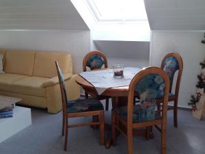 ein Wohnzimmer mit einem Tisch, Stühlen und einem Sofa in der Unterkunft Apartment in Kniebis with garden seating area in Kniebis