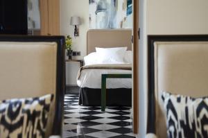 - une chambre avec un lit et un sol en damier noir et blanc dans l'établissement Aguilas5 SevillaSuites, à Séville