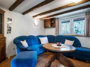 シュマレンベルクにあるModern Holiday home in Oberkirchen with Gardenのリビングルーム(青いソファ、テーブル付)