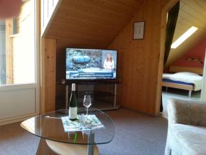 a living room with a tv and a glass table at Pleasing Apartment in Traben Trarbach with Balcony in Wolf