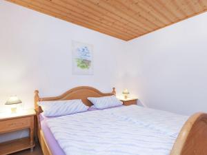バート・リッポルサウにあるApartment with a viewのベッドルーム1室(白いシーツと木製の天井が備わるベッド1台付)