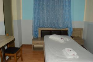 um pequeno quarto com uma cama e uma cortina azul em Diethnes Hotel em Atenas