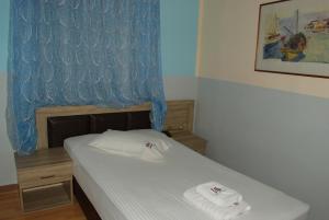 um pequeno quarto com uma cama com toalhas em Diethnes Hotel em Atenas