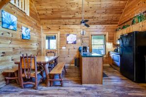 a kitchen with a table and a black refrigerator at Laketown Bears - Pool Table & Hot Tub! in Sevierville
