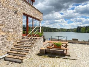 ein Backsteingebäude mit einem Picknicktisch und einem See in der Unterkunft Penzion Ratmírák in Malý Ratmírov