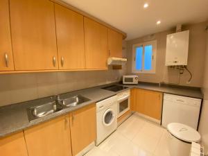 a kitchen with a sink and a washing machine at Anais Apartments by gaiarooms in Barcelona