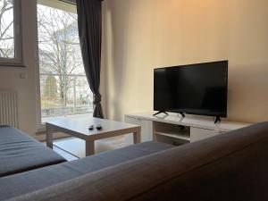 a living room with a tv and a couch and a table at NorthApartments Chemnitz in Chemnitz