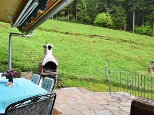 MühlenbachにあるIdyllic holiday home with private terraceのテーブルと椅子、バードハウスのあるパティオ