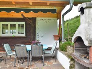 a table and chairs on a patio with an outdoor oven at Idyllic holiday home with private terrace in Mühlenbach