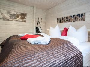 ヴィンターベルクにあるCozy Holiday Home in Niedersfeld with Private Gardenのベッドルーム1室(大型ベッド1台、白と赤の枕付)