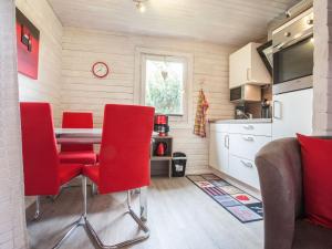 ヴィンターベルクにあるCozy Holiday Home in Niedersfeld with Private Gardenのキッチン(テーブル、赤い椅子付)