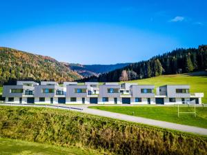 a large building in the middle of a field at Naturpark Chalets Lambrecht by ALPS RESORTS in Sankt Lambrecht
