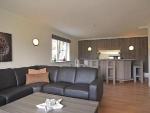 Il comprend un salon avec un canapé et une cuisine. dans l'établissement house with private sauna garden and terrace, à Hallenberg