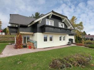 a white and black house with a yard at Apartment near the forest in Frauenwald